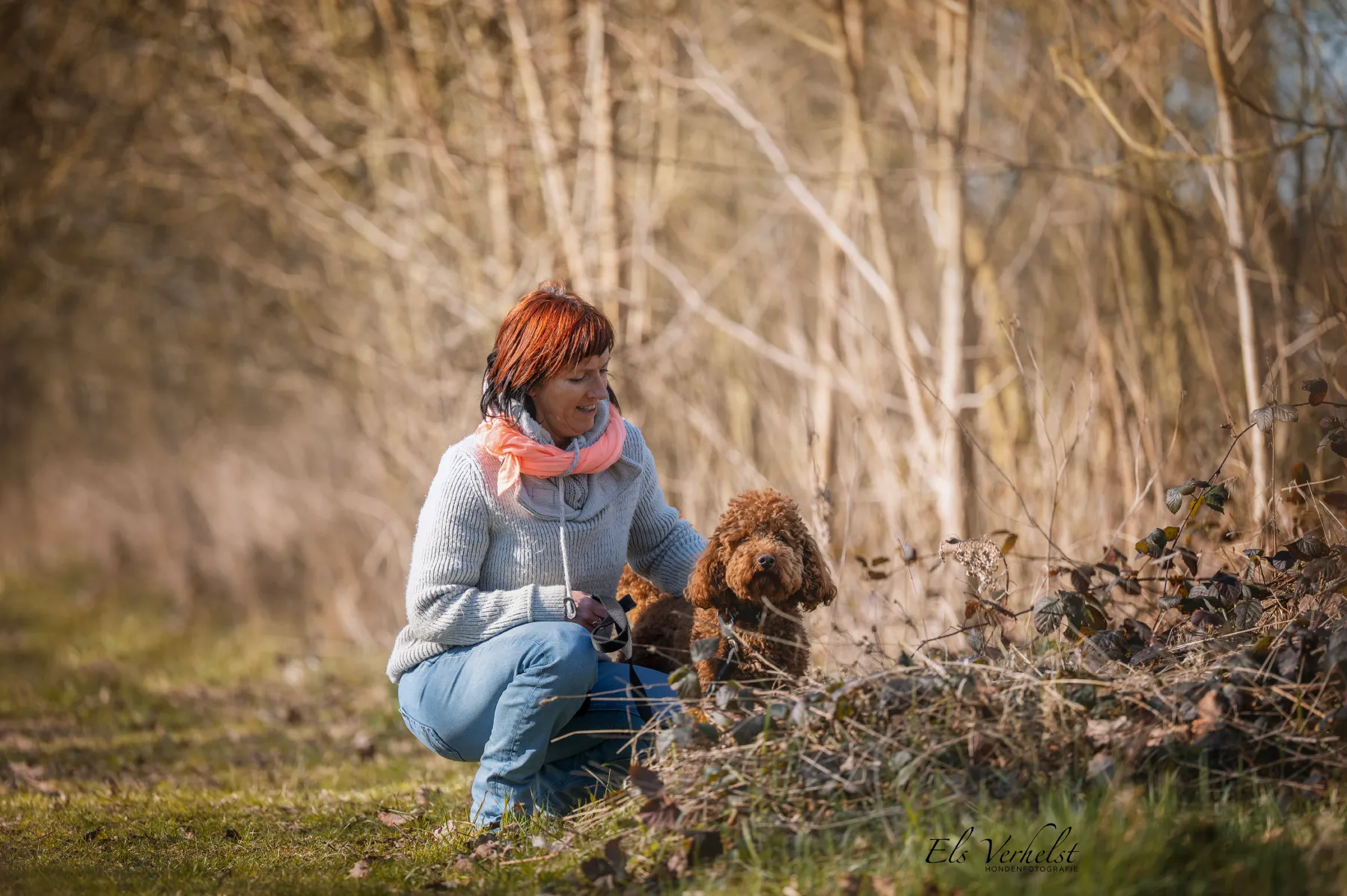 Françoise knielt bij een bruine hond in het gras